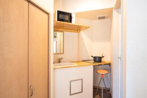 a small kitchen with a sink and a counter at BEYOND HOTEL Takayama 2nd in Takayama
