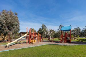 a playground with a slide in a park at Ramada Resort by Wyndham Phillip Island in Cowes