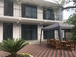un tavolo e sedie sotto un ombrellone di fronte a un edificio di ALEX'S HOUSE a Kobuleti