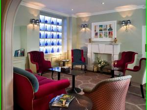 a living room with red chairs and a fireplace at Francis Hotel Bath in Bath