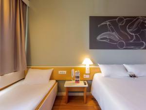 Habitación con 2 camas y mesa con lámpara. en Ibis Elche, en Elche 37 fotos más