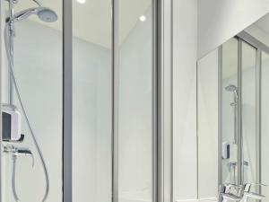 a bathroom with a shower with glass doors at hotelF1 Beauvais in Beauvais