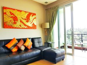 um sofá de couro preto numa sala de estar com um quadro em Sea & Sky Karon Beach by PHR em Praia de Karon