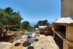 a patio with four chairs and a table with a view of the ocean at REDSTONE luxury apartments in Hvar