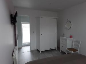 ein Schlafzimmer mit einer weißen Tür, einer Kommode und einem Spiegel in der Unterkunft Le Gîte Dameryat in Damery