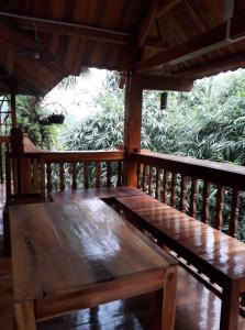 um banco de madeira sentado num alpendre em Ha Giang Faithien Homestay em Ha Giang