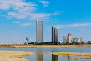 a city skyline with tall buildings and a body of water at Swiss Grand Nanchang in Nanchang