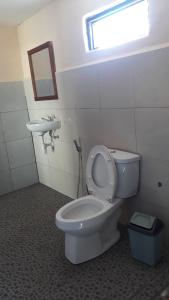 a bathroom with a toilet and a sink at Ila Homestay in Senaru