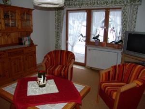 uma sala de estar com duas cadeiras, uma mesa e uma televisão em Haus Alpenglühn em Engedey