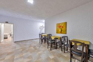 a room with tables and chairs and a painting on the wall at Halaris Rooms in Ermoupoli