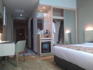 Purest Hotel Sungai Petani في سونغاي بيتاني: غرفة فندقية بها سرير وموقد
