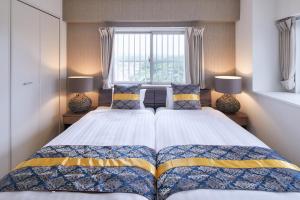 a bedroom with two beds and a window at Comfort Villa in Motobu