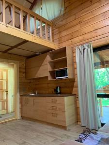eine Küche in einem Blockhaus mit einem Loft in der Unterkunft GOL&Wood in Stepashki