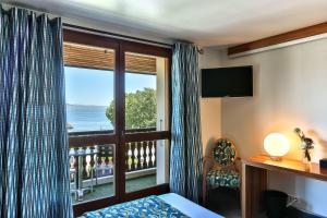 una habitación de hotel con vistas al océano en Le Pré de la Cure en Yvoire
