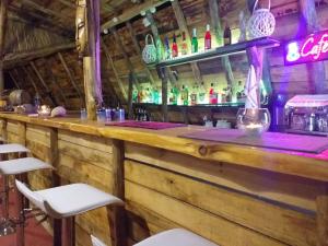 a bar with a wooden counter and some chairs at Caretta Village in Toroni