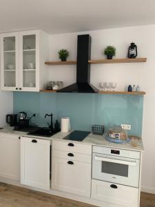 a kitchen with white cabinets and a stove top oven at apartament Wakacje w Rowach in Rowy