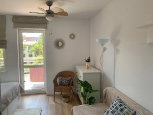 a living room with a ceiling fan and a chair at apartament Wakacje w Rowach in Rowy
