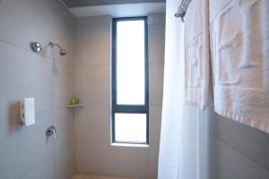 a bathroom with a shower and a window at Hotel Ease Mong Kok in Hong Kong
