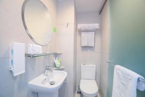 a bathroom with a sink and a toilet and a mirror at Hotel Ease Mong Kok in Hong Kong