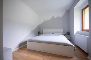 een slaapkamer met een groot wit bed op een zolder bij Hiša Urška in Log pod Mangartom