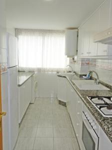 a white kitchen with a sink and a stove at FLORESTA GANDIA - Solo Familias in Playa de Gandia