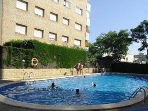 un grupo de personas en una piscina al lado de un edificio en Estudio SALOU, en Salou