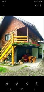a house with a yellow staircase and flowers on it at Pensiunea Padina in Bran