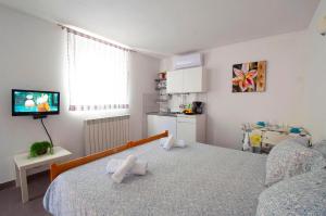 a bedroom with a bed with white towels on it at Apartment Dva Oriha in Funtana