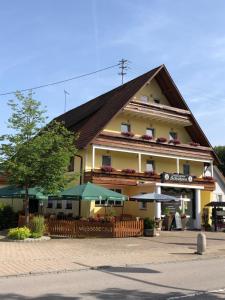 un grand bâtiment jaune avec un toit en gambrel dans l'établissement Hotel-Restaurant Gasthof zum Schützen, à Baiersbronn