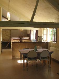 a table and chairs in a room with a bed at 4 Collines in Hagnicourt