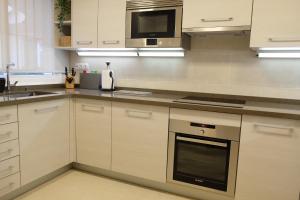 a kitchen with white cabinets and a stove top oven at luxury modern apartment with terrace, pool and garage! in Marbella