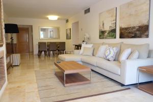 a living room with a white couch and a table at luxury modern apartment with terrace, pool and garage! in Marbella