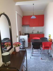 イラクリオン・タウンにあるComeHomeのキッチン(赤いキャビネット、テーブル、椅子付)