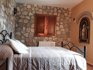 a bedroom with a stone wall with a bed at Casita Vista Alegre in Castril +57 photos