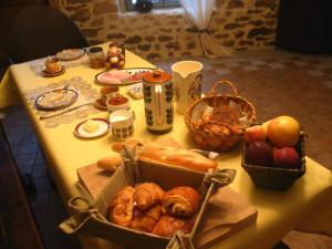 a table with a box of pastries and baskets of bread at 4 Collines in Hagnicourt +20 photos