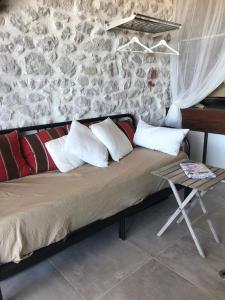 uma cama num quarto com uma parede de pedra em LE CABANON BLEU SUR LA PLAGE em Marselha