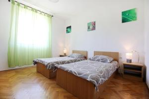 a bedroom with two beds and a large window at Large gardens 2 in Bibinje