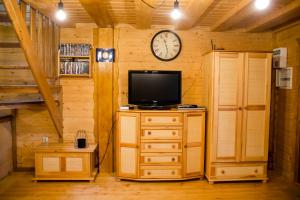 a room with a television and a clock on a wall at Rajskie in Rajskie Sakowczyk