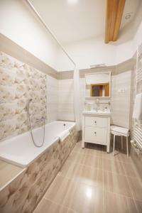 uma casa de banho branca com uma banheira e um lavatório em TópART Apartman I em Balatonfenyves
