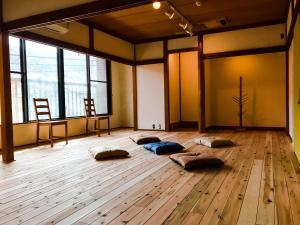 um quarto com almofadas num piso de madeira com janelas em Yugawara Retreat Goen no Mori em Yugawara