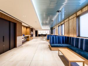 a waiting room with blue seats in a building at Hotel Gracery Osaka Namba in Osaka