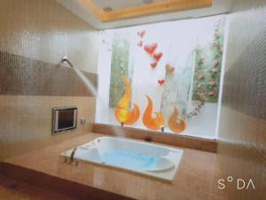 La salle de bains est pourvue d'une baignoire et d'une peinture murale. dans l'établissement MUDU BREEZE MOTEL, à Shulin