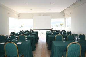 a conference room with green tables and chairs and a white screen at Hotel Green en Marbella in Maitencillo