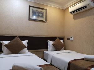 Postel nebo postele na pokoji v ubytování Hotel Grand Palace Ampang