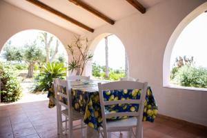 a dining room with a table and chairs and windows at Residenza il Normanno - La terrazza sul mare in Santa Domenica