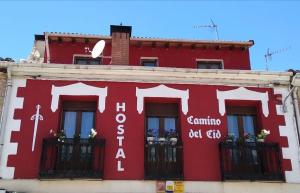 czerwony budynek z krzyżem na boku w obiekcie Hostal Camino Del Cid w mieście Huerta del Rey
