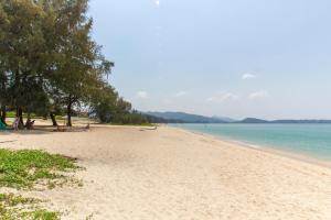 una playa de arena con árboles y agua en Laguna Park Townhomes & Villas en Bang Tao Beach