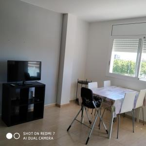 a living room with a dining room table and a tv at Apartment Verge de Montserrat in Cambrils