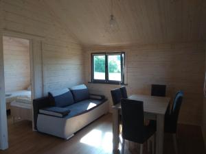 a room with a couch and a table in a room at Domki Nad Stawem Mazury in Mrągowo