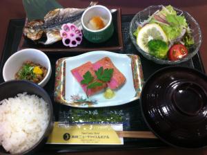 a tray of food with rice and fish and vegetables at Hamada New Castle Hotel in Hamada